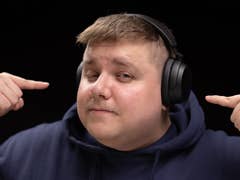 Antoine portant le Sennheiser Accentum Wireless sur la tête, vu de face, et pointant de ses deux index chaque oreillette du casque