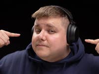 Antoine portant le Sennheiser Accentum Wireless sur la tête, vu de face, et pointant de ses deux index chaque oreillette du casque