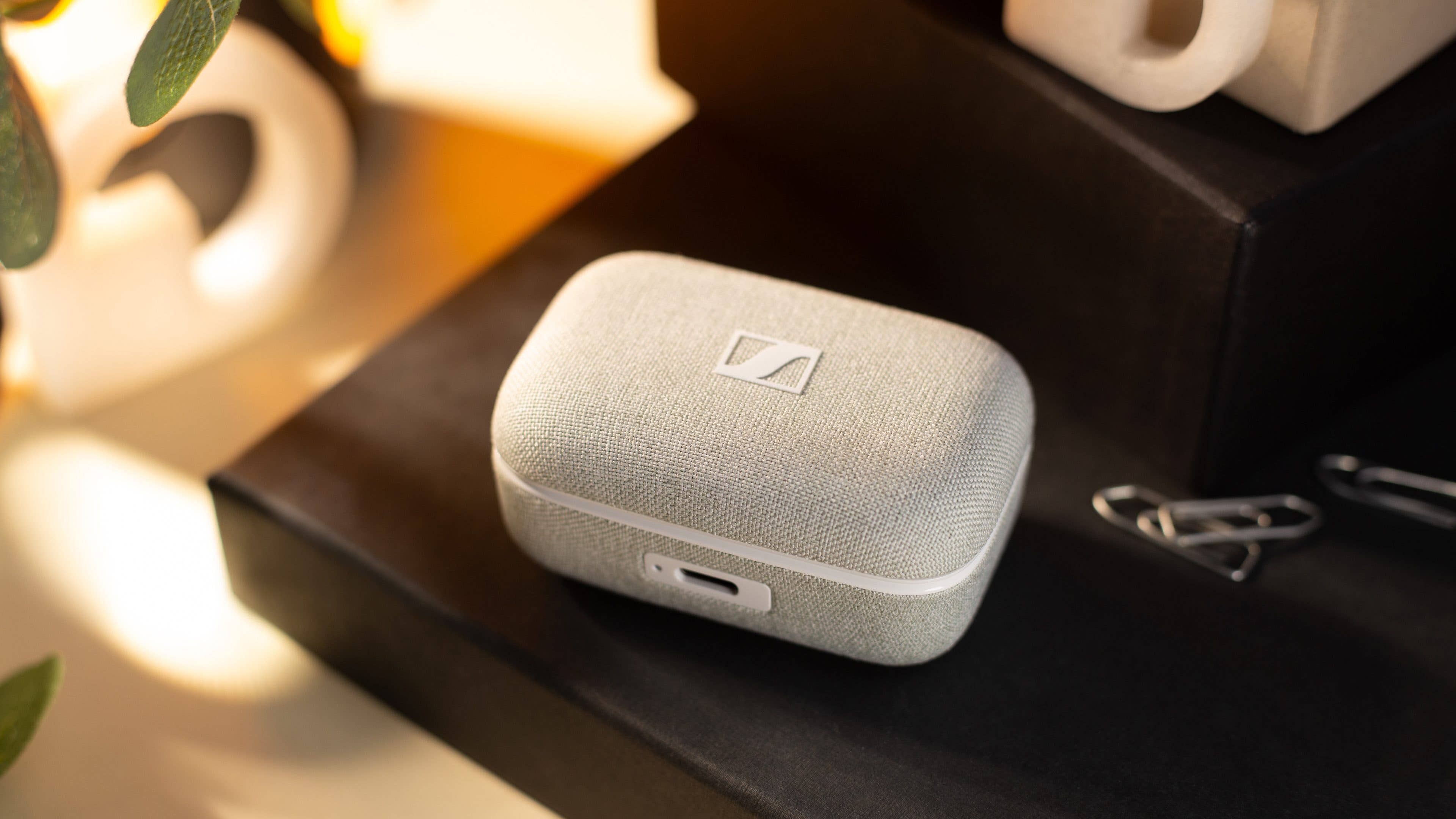 Le boîtier de recharge des Sennheiser Momentum True Wireless 4 posé sur une table, vu de haut avec son couvercle fermé