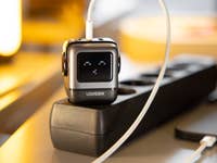 Le chargeur Ugreen Nexode Robot GaN branché sur une multiprise en connecté à un iPhone posé à côté