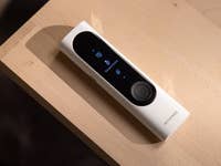 Un appareil Withings BeamO posé sur une surface en bois, affichant un écran de mesure de température.