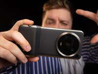 Le Xiaomi 14 Ultra vu de dos, tenu horizontalement par un homme se tenant en arrière-plan