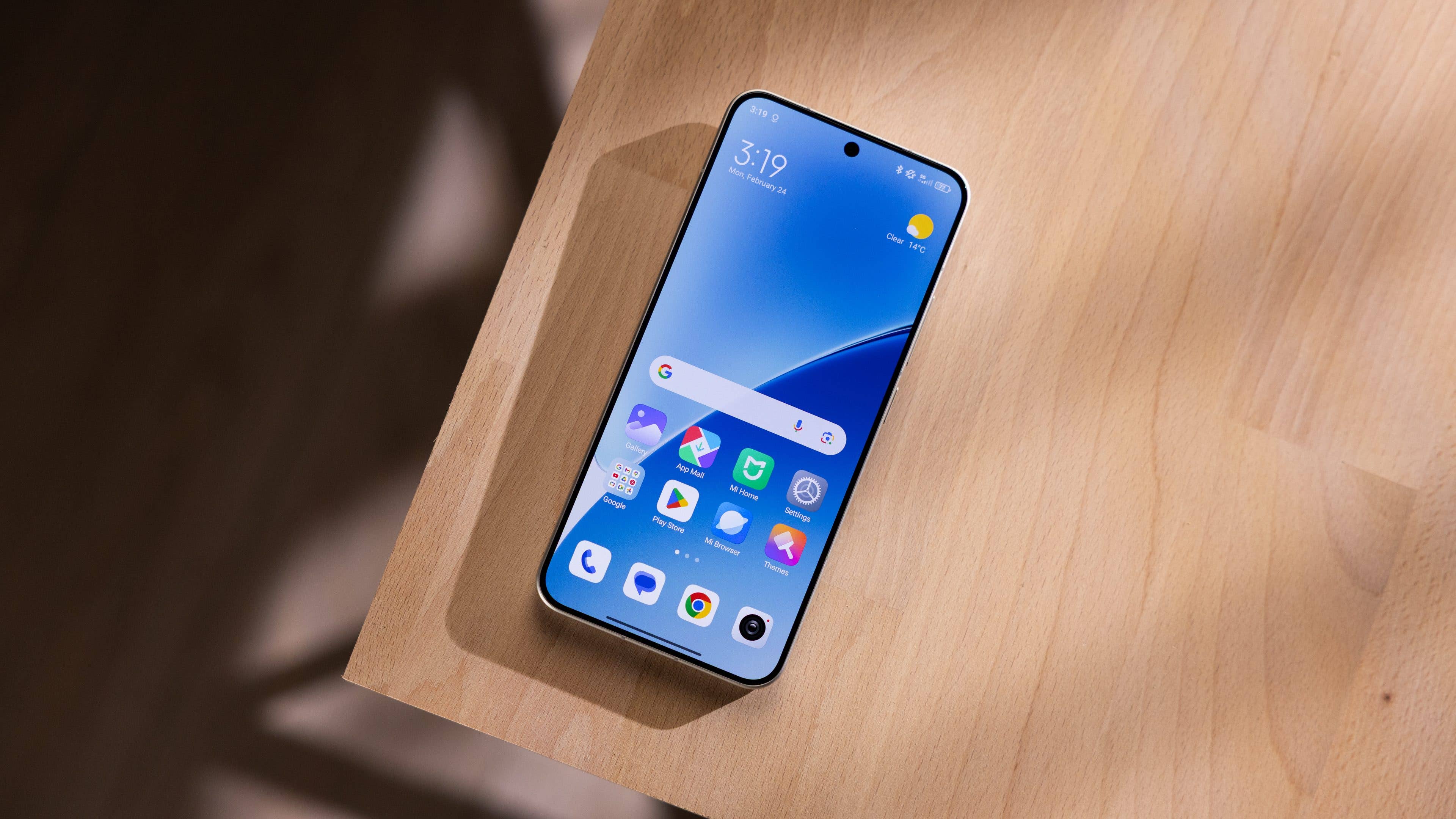 Un smartphone Xiaomi 15 sur une surface en bois, affichant une interface d'application colorée à 15h19.