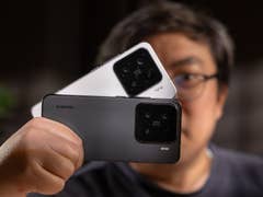 Une personne tenant deux smartphones Xiaomi 15, un blanc et un noir, avec des objectifs de caméra visibles.