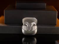 Écouteurs sans fil Xiaomi Buds 5 exposés sur une surface sombre avec un éclairage subtil.