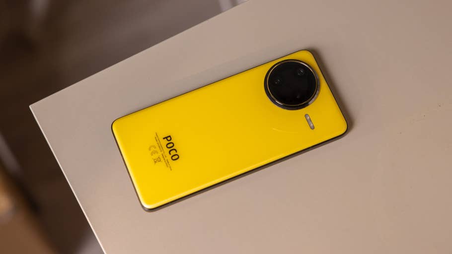 Un smartphone Poco F7 Ultra jaune posé sur une surface beige.