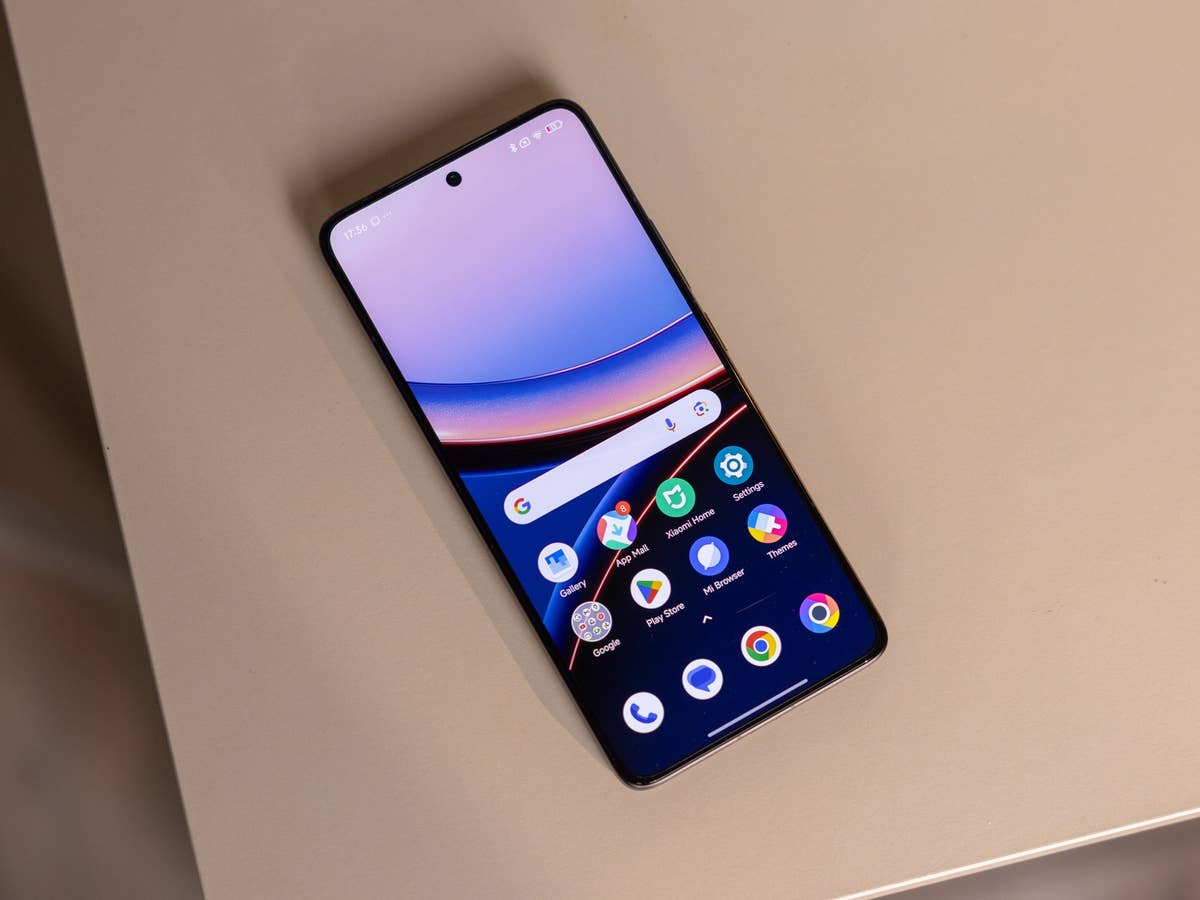 nextpit_Xiaomi_F7_Ultra_Display.jpg Un smartphone Poco F7 Ultra affichant un écran d'accueil coloré sur une surface beige.