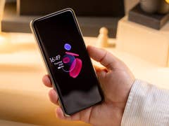 Le Xiaomi 14 Ultra vu de face et tenu dans une main avec son Always on Display allumé