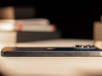 L'iPhone 15 Pro Max vu de côté et posé à plat face contre terre sur une table