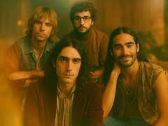 Portrait de groupe de quatre musiciens, avec une esthétique vintage chaleureuse.