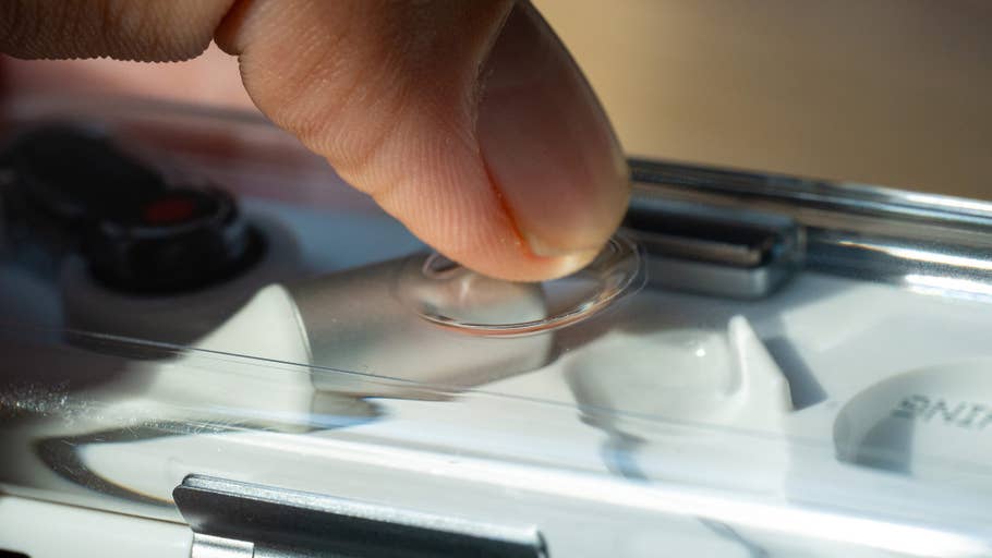 Un doigt appuie sur un bouton transparent du0027un étui contenant des écouteurs Nothing Ear.