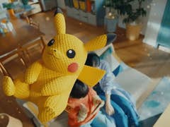 Gros plan d'un jouet en peluche Pikachu avec une expression ludique, flottant dans un fond de pièce confortable.