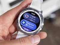 Une personne tenant une Samsung Galaxy Watch 8 Classic affichant des mesures de santé et un score d'énergie.