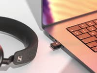 Adaptateur USB Bluetooth Sennheiser BTD 700 à côté des écouteurs et d'un ordinateur portable.