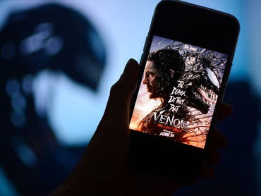 Poster de Venom 3 sur un smartphone avec une silhouette d'ombre en arrière-plan.