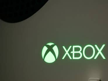 Gros plan d'un logo Xbox vert illuminé sur une console.