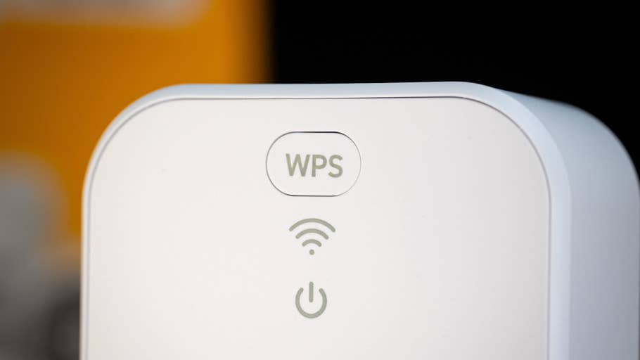 Gros plan du0027un appareil blanc affichant les symboles WPS et Wi-Fi avec un bouton du0027alimentation.