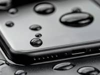 Un smartphone avec des gouttes d'eau sur sa surface, montrant la résistance à l'eau.