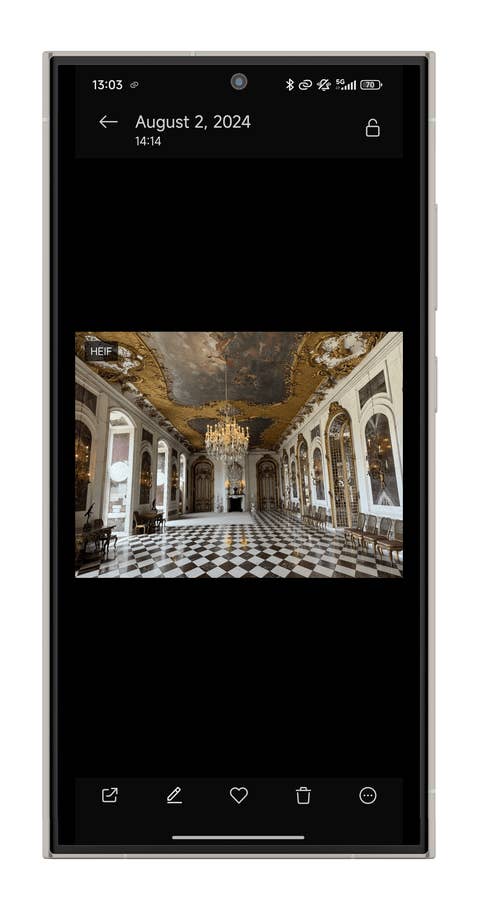 Une grande salle avec un lustre, un plafond orné et un sol en damier, capturée le 2 août 2024.