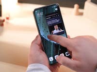 Le Xiaomi 14 Ultra tenu dans une main avec un doigt touchant son écran pour ouvrir une application en mode fenêtré